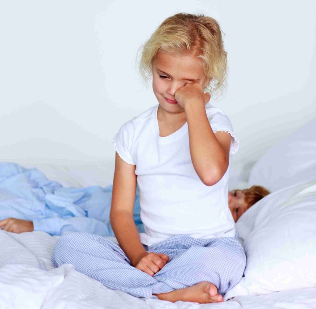 Kind in Bett mit Pyjama